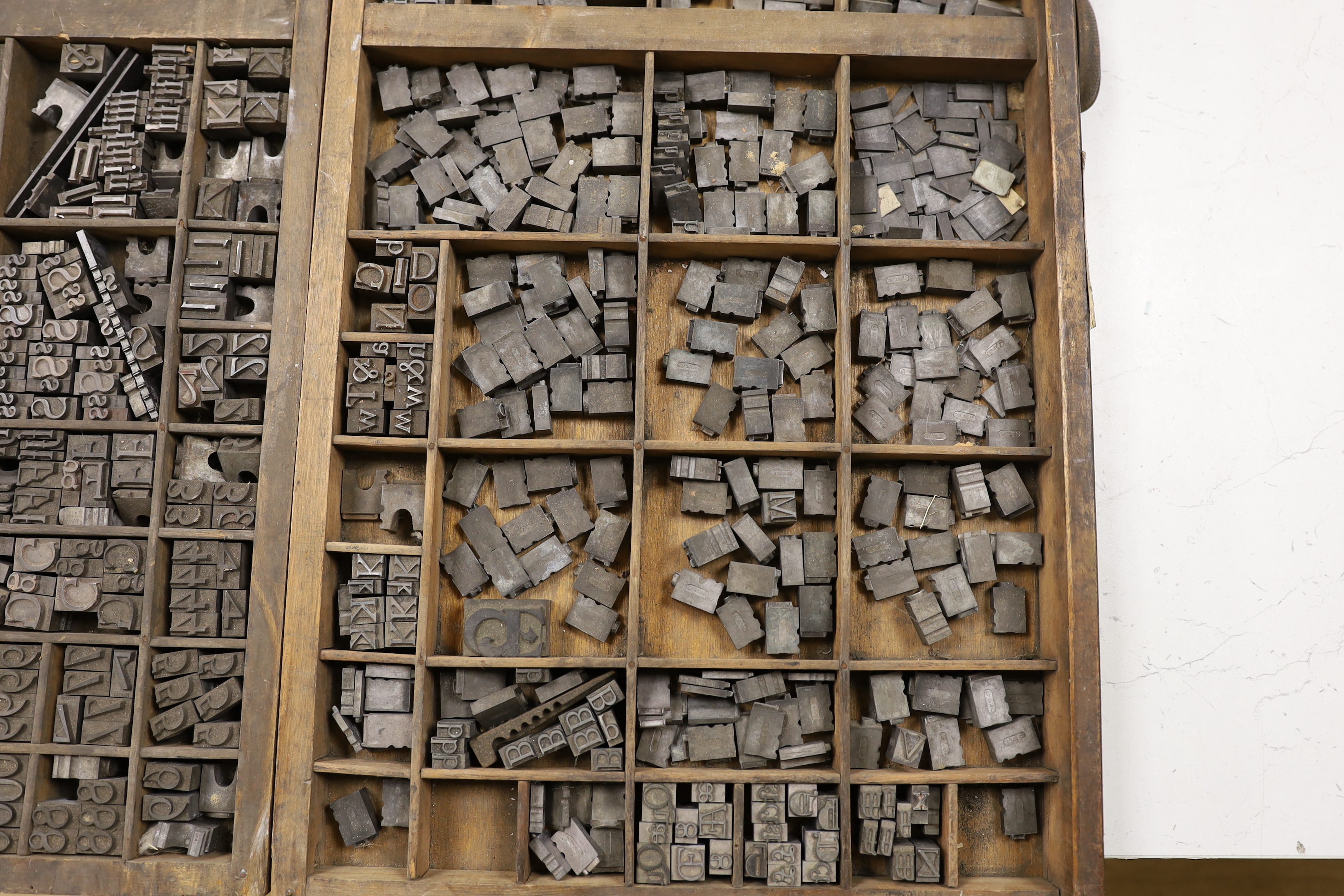 Three trays of metal printing type: chases, quoins and spacing bars
